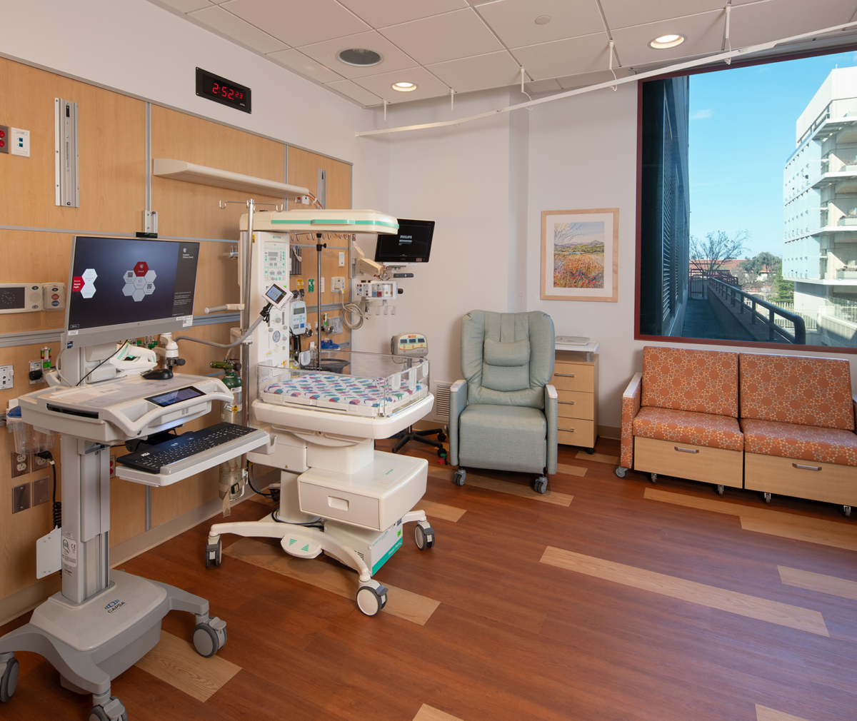 A new room at the hospital's NICU featuring a newborn bed and room for the parents.