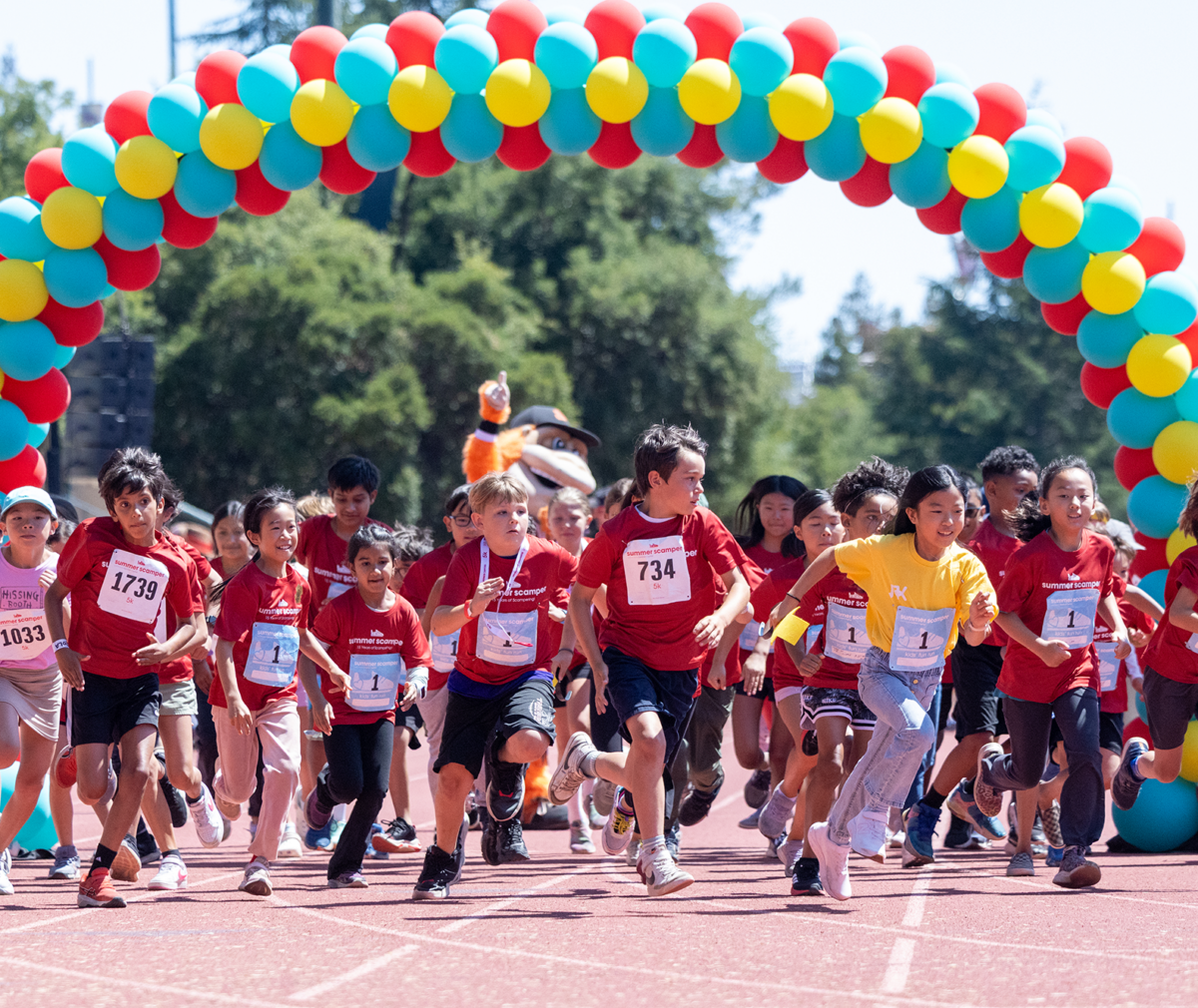 Kids start the kids fun run race on the Stanford Track at Summer Scamper.