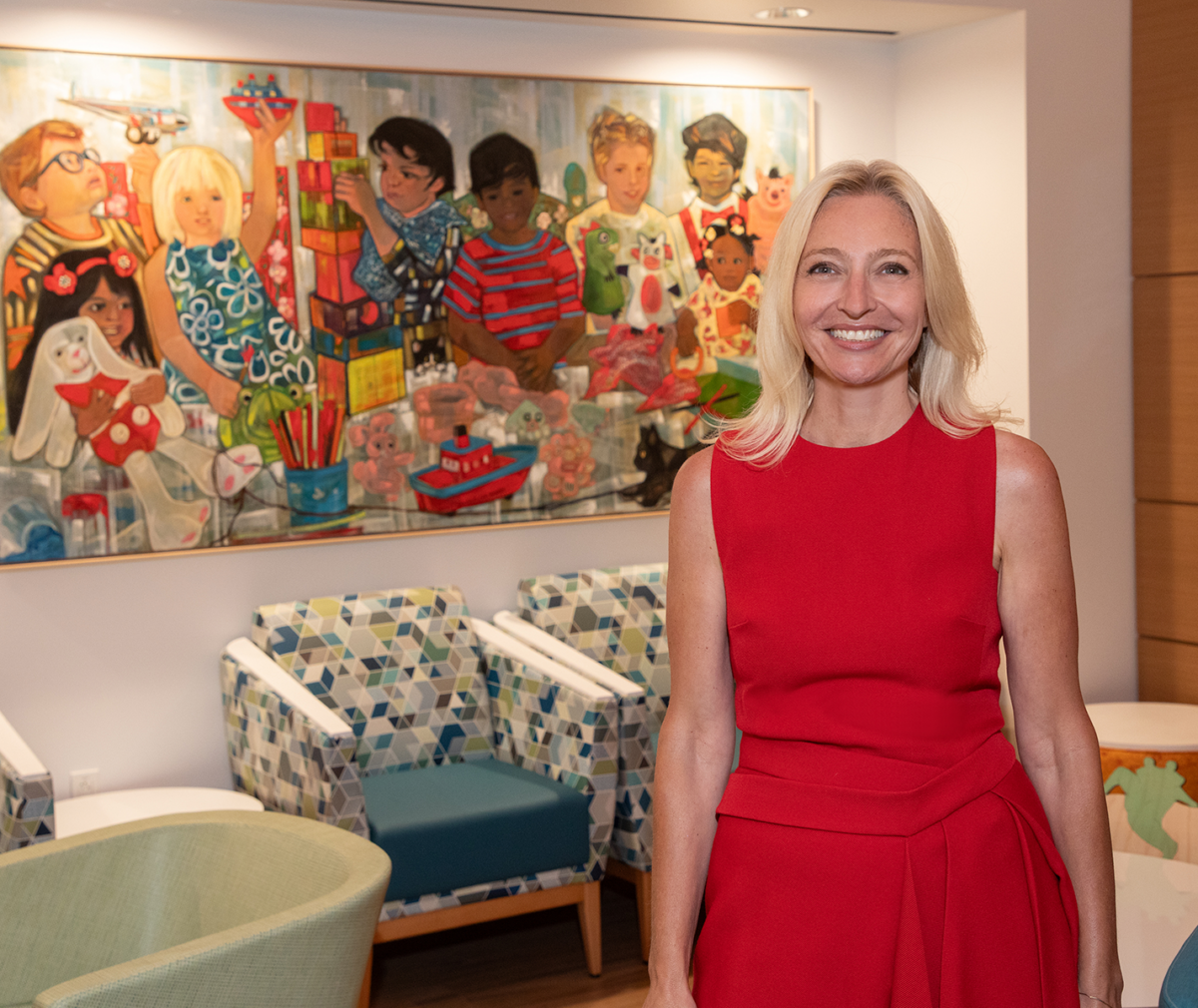 Dr Tanja Gruber stands in front of a painting in the waiting room of the new Bass Center Clinic and Infusion Center
