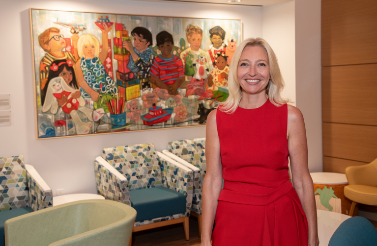 Dr Tanja Gruber stands in front of a painting in the waiting room of the new Bass Center Clinic and Infusion Center