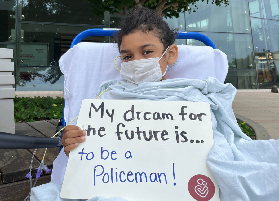Patient holding a white board that reads "My dream for the future is to be a policeman."