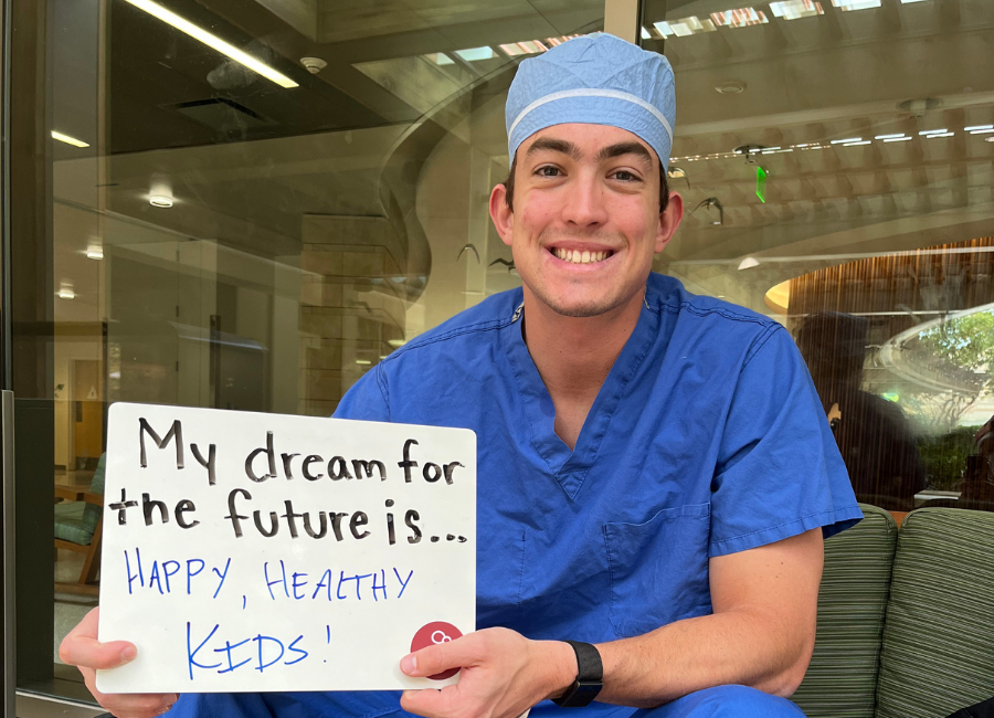 Hospital staff holding a white board that reads "My dream for the future is Happy, Healthy Kids."