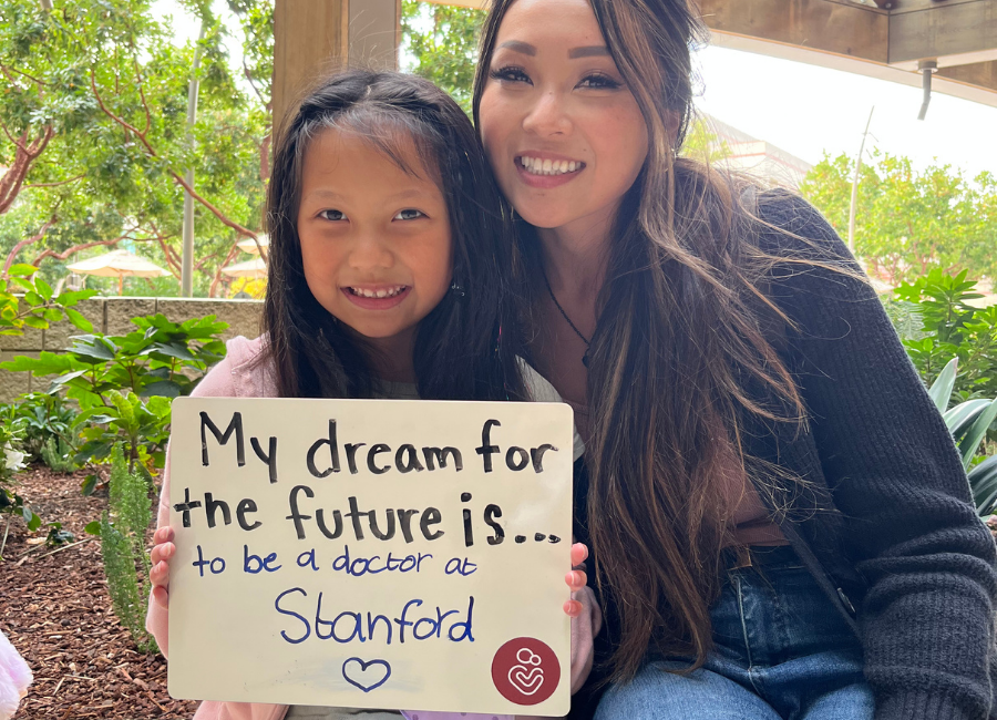 Patient holding a white board that reads "My dream for the future is to be a doctor at Stanford."