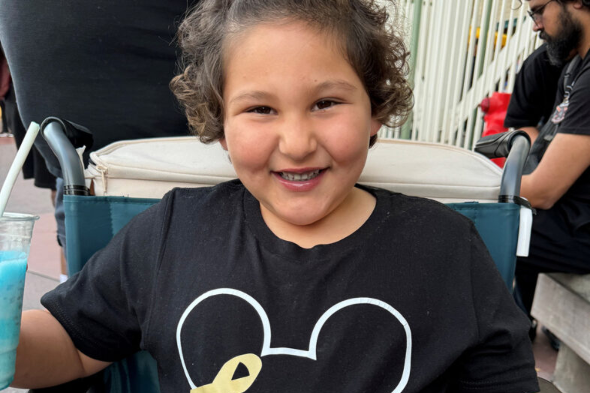 Packard Children's pediatric cancer patient in a Disney t-shirt smiling at the camera.