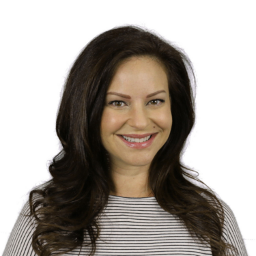 A person with long dark brown hair smiles at the camera against a white background. They wear a black-and-white striped top.