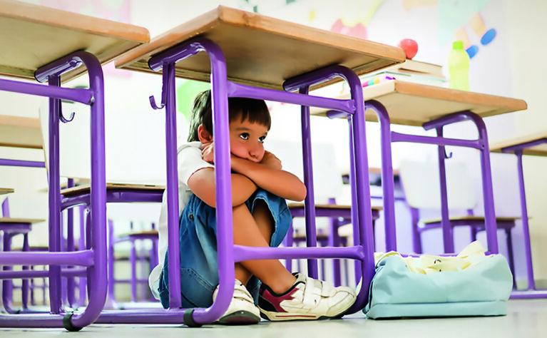 Shy kid hiding under table
