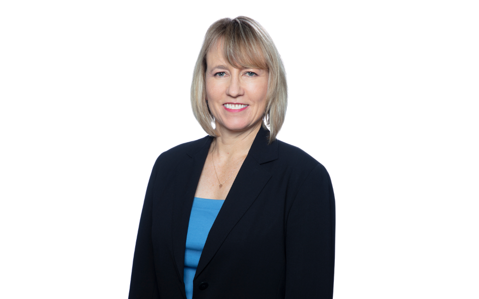 Stanford reproductive health physician posing for a picture and smiling at the camera. They wear professional attire including a blue top and black blazer.