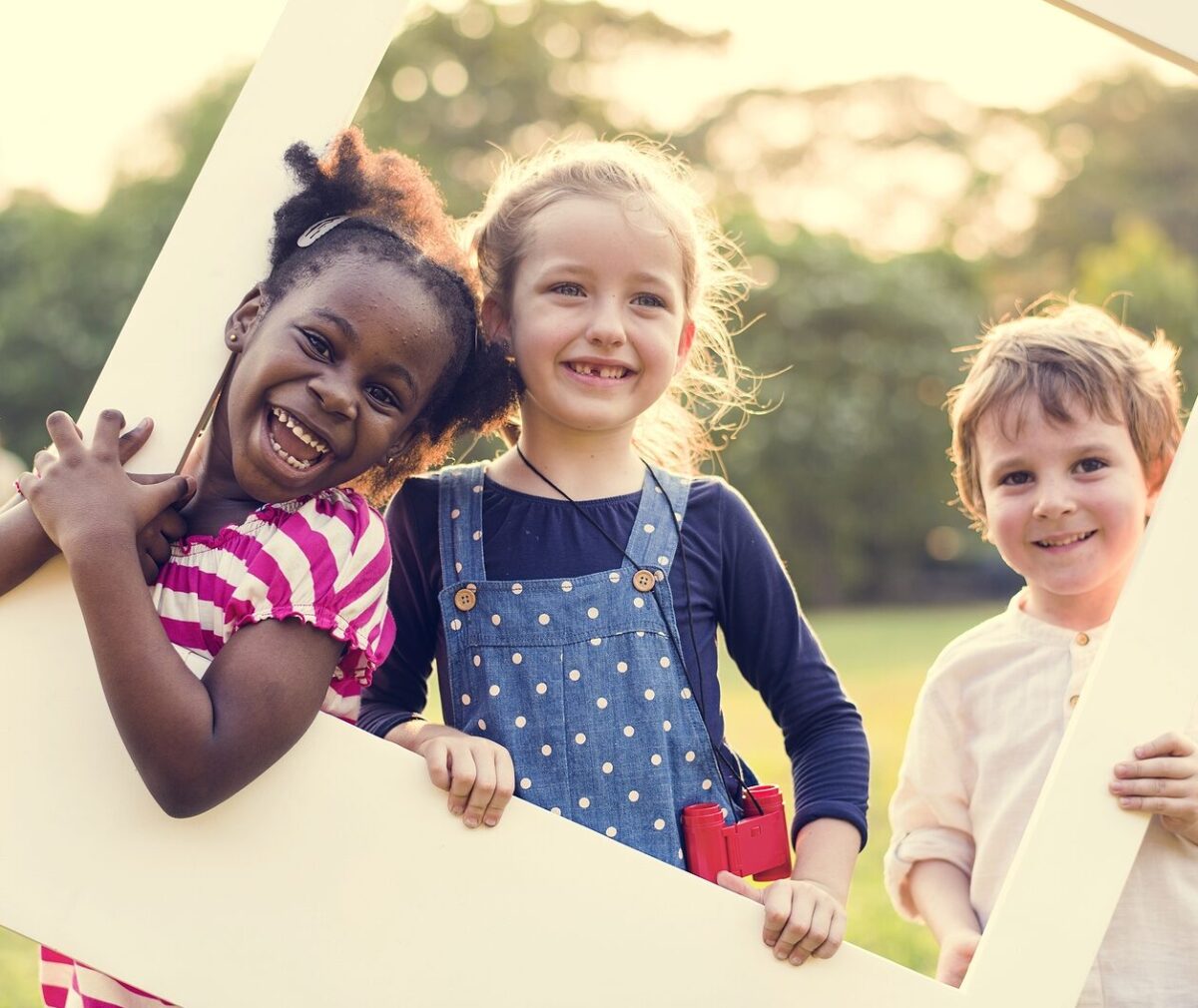 Little Kids with Photo Frame at Grass Field