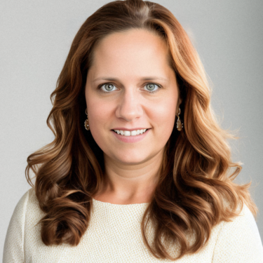 Professional studio headshot of a woman with long, wavy auburn hair and green eyes, smiling warmly at the camera. She's wearing gold hoop earrings and a cream-colored textured top, photographed against a plain light gray background.