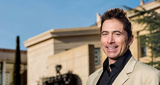 A professional headshot of Dennis Wall taken outside.