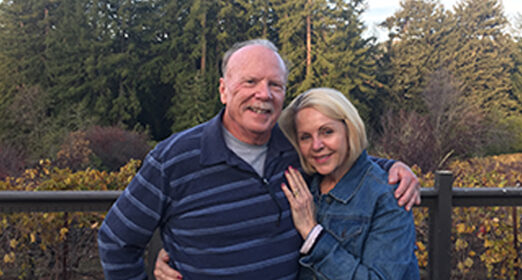 Two adults standing next to each other posing for picture.