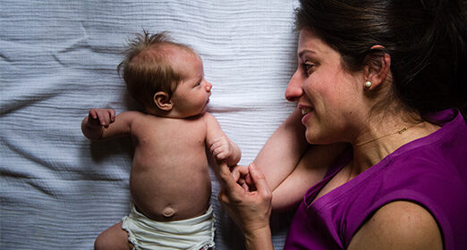 Adult laying next to a baby.
