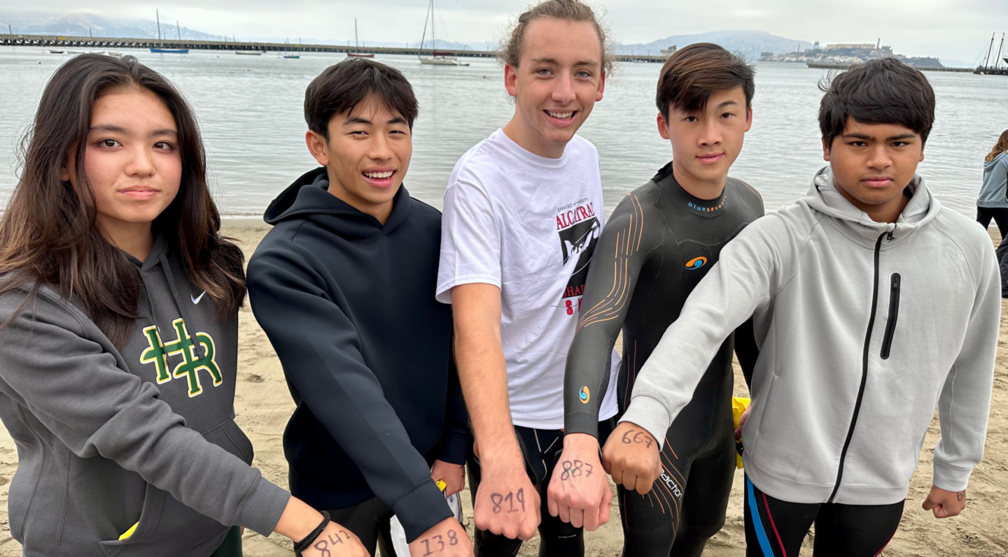 Group of students volunteering for Lucile Packard Foundation showing numbers on their hand to camera.