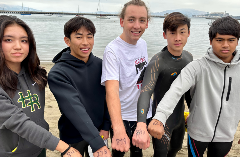 Group of students volunteering for Lucile Packard Foundation showing numbers on their hand to camera.