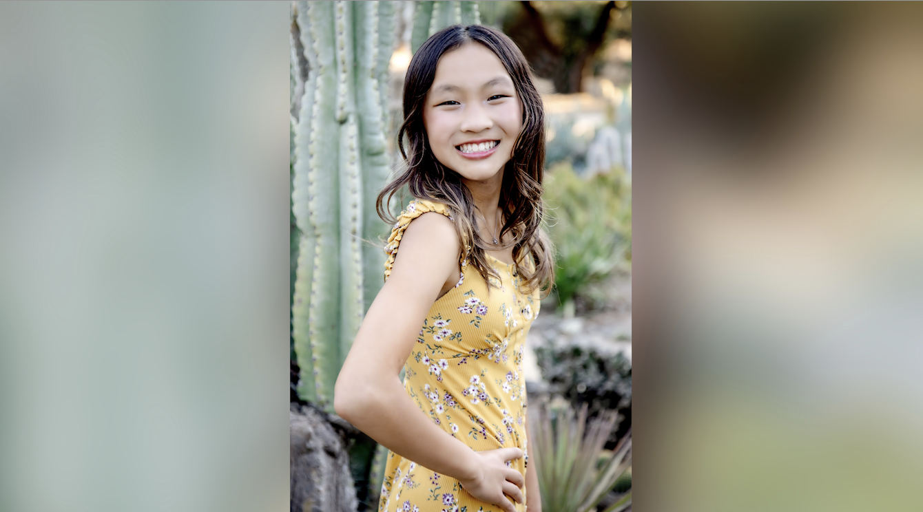 Photo of Jocelyn posing in front of greenery