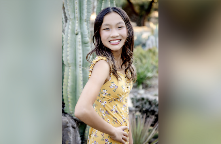 Photo of Jocelyn posing in front of greenery