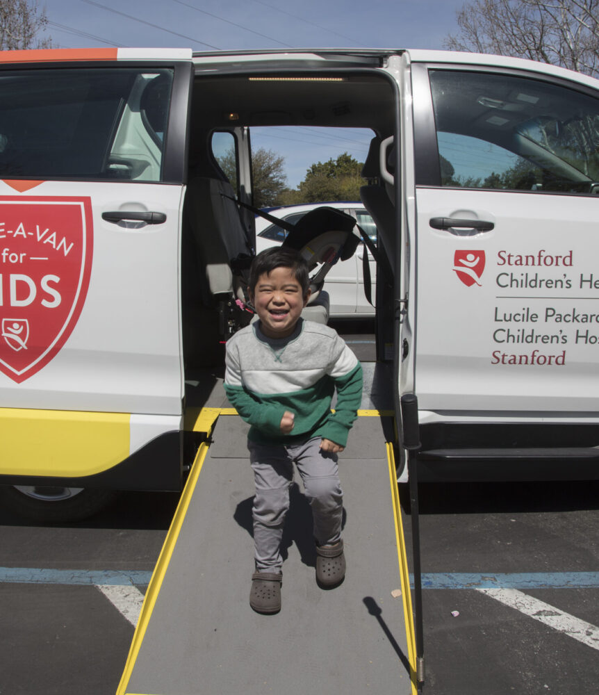 Boy runs down ramp of a medical transportation van