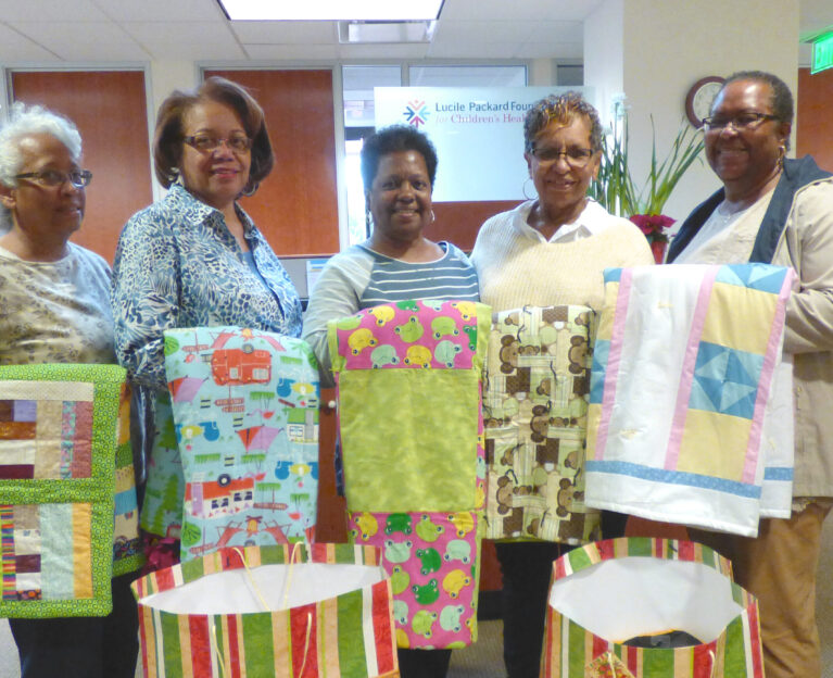 People holding quilts
