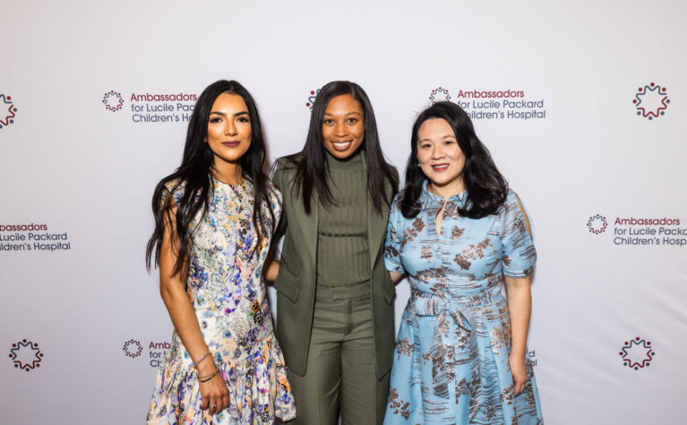 Two ambassadors pose with Allyson Felix at an event